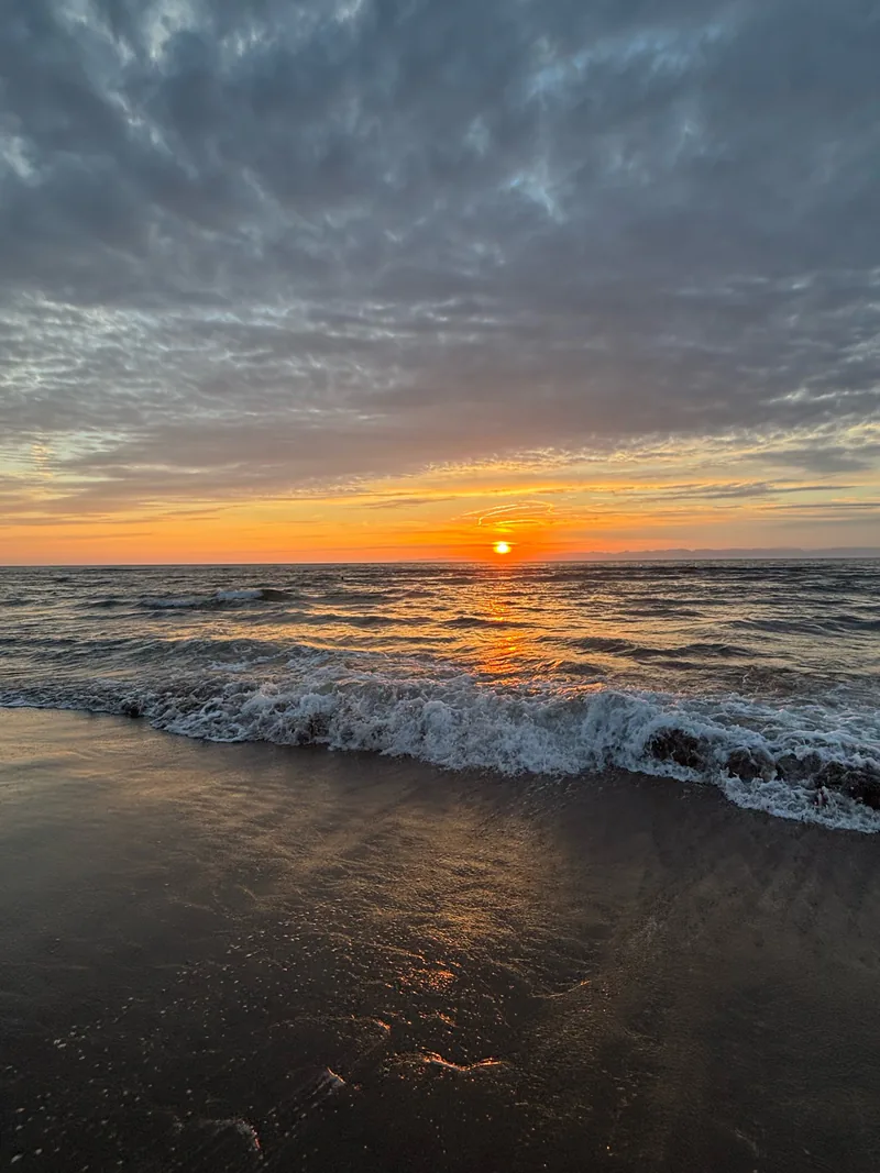 波打ち際を照らす海の夕日